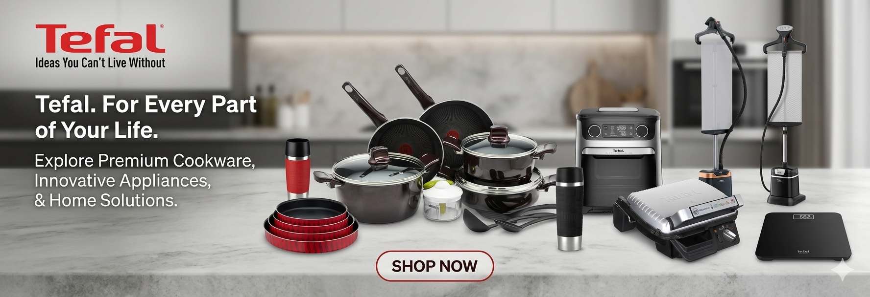 Tefal cookware and appliances displayed on a table with a kitchen background.
